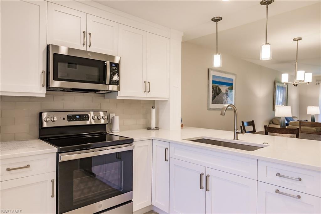 a kitchen with stainless steel appliances a stove a microwave and cabinets