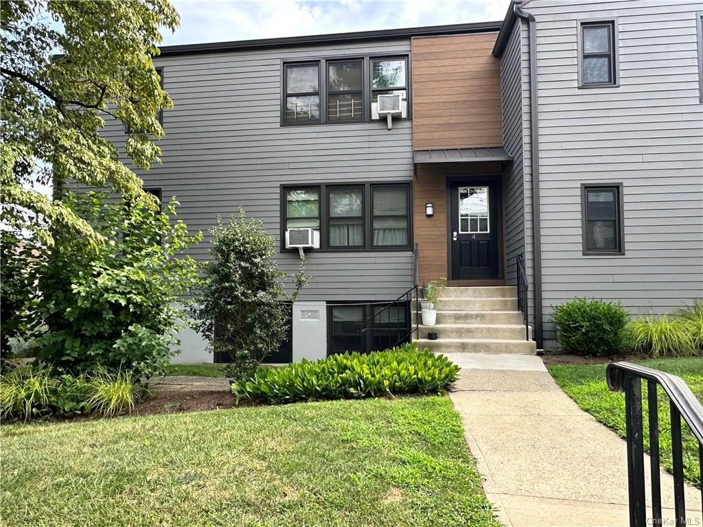 a front view of a house with a yard and outdoor seating