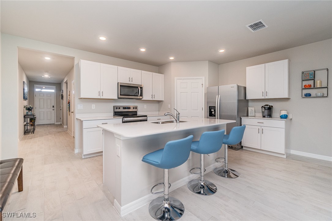 a kitchen with kitchen island granite countertop a sink and a refrigerator