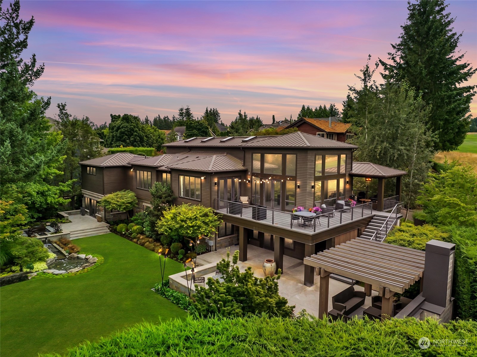 a front view of a house with garden and sitting area