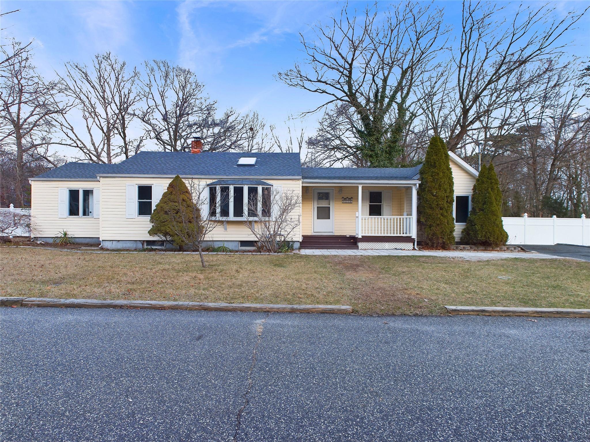 Ranch-style house with covered porch and a front lawn