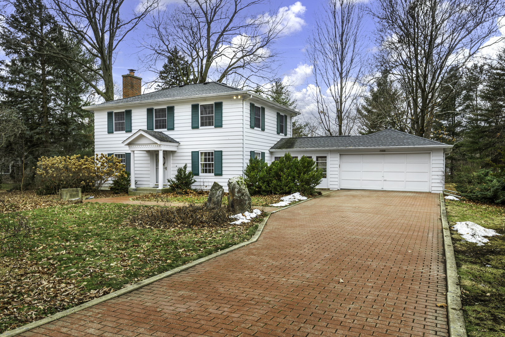 a front view of a house with a yard and trees