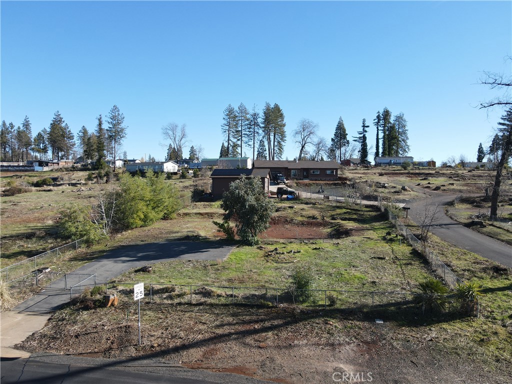 a view of a yard with wooden fence and trees