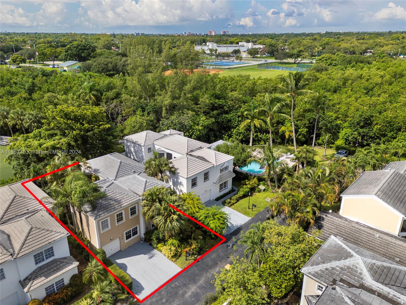 an aerial view of residential houses with outdoor space and trees