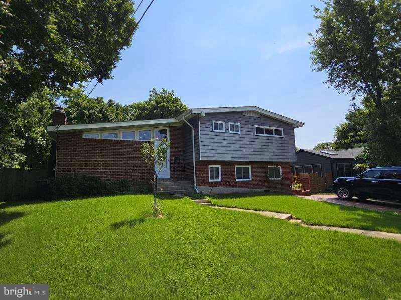 a view of house with a big yard and potted plants and large trees