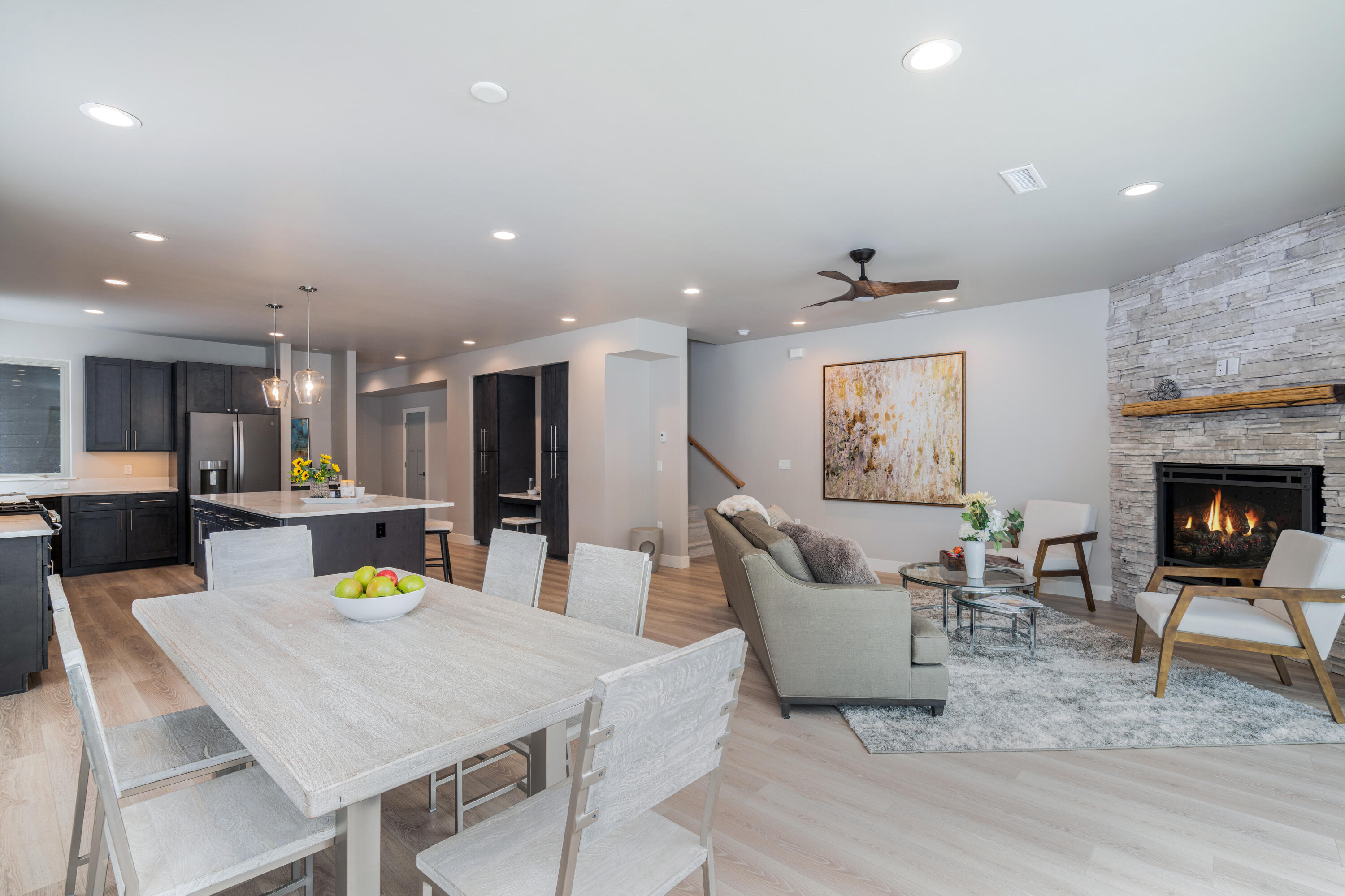 a living room with stainless steel appliances furniture a dining table and kitchen view