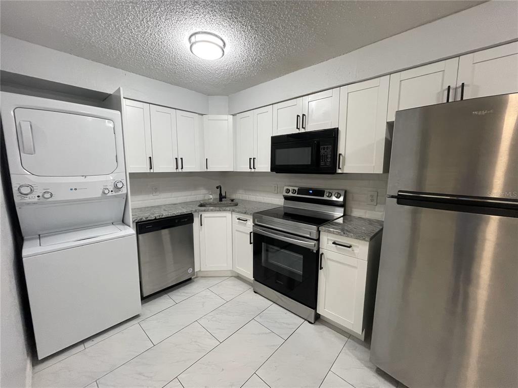 a kitchen with cabinets stainless steel appliances and a counter space