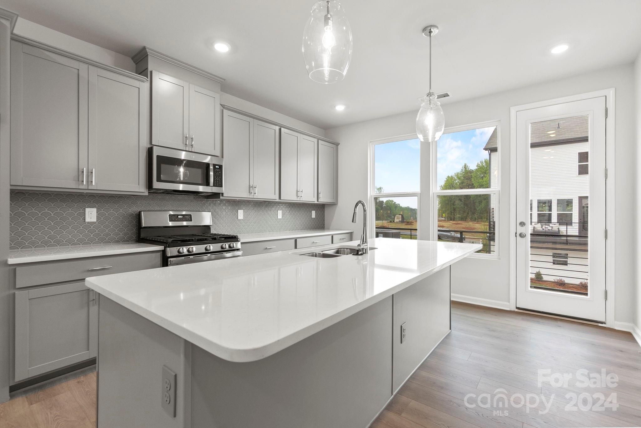 a large kitchen with kitchen island a sink stainless steel appliances and cabinets