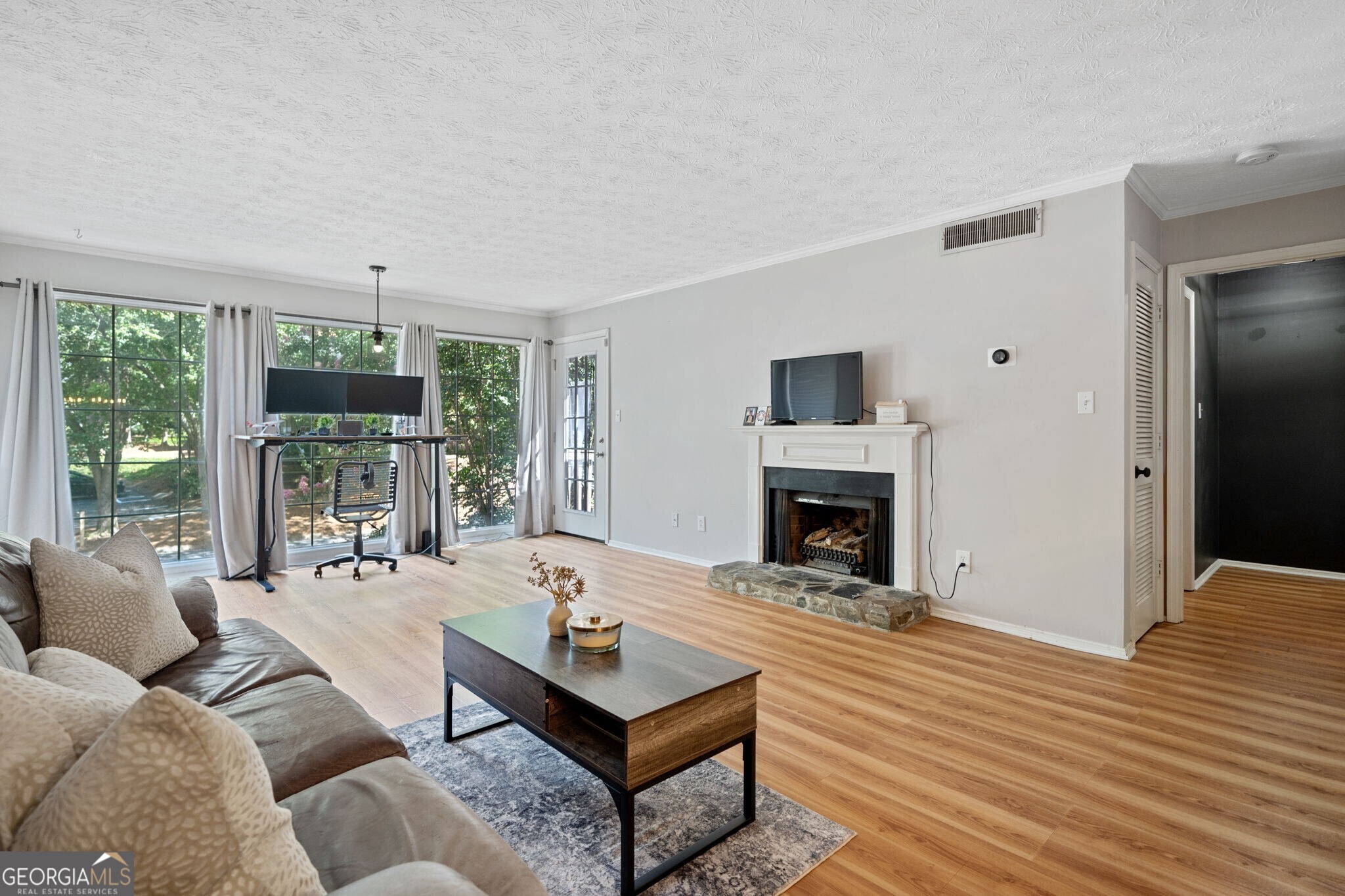 a living room with furniture large window and a fireplace