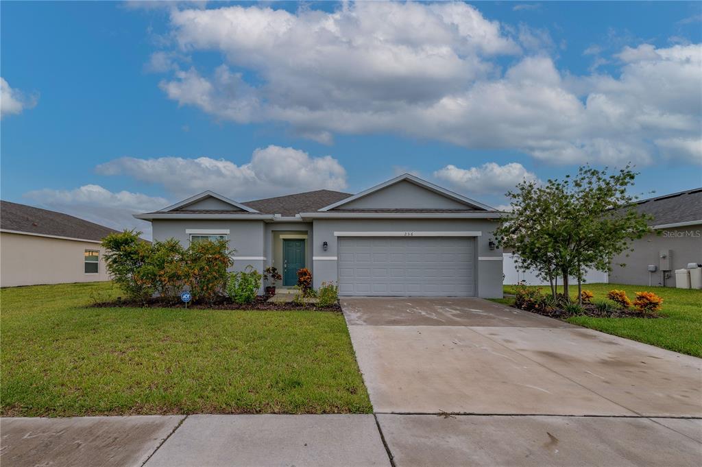 a front view of a house with a yard and garage