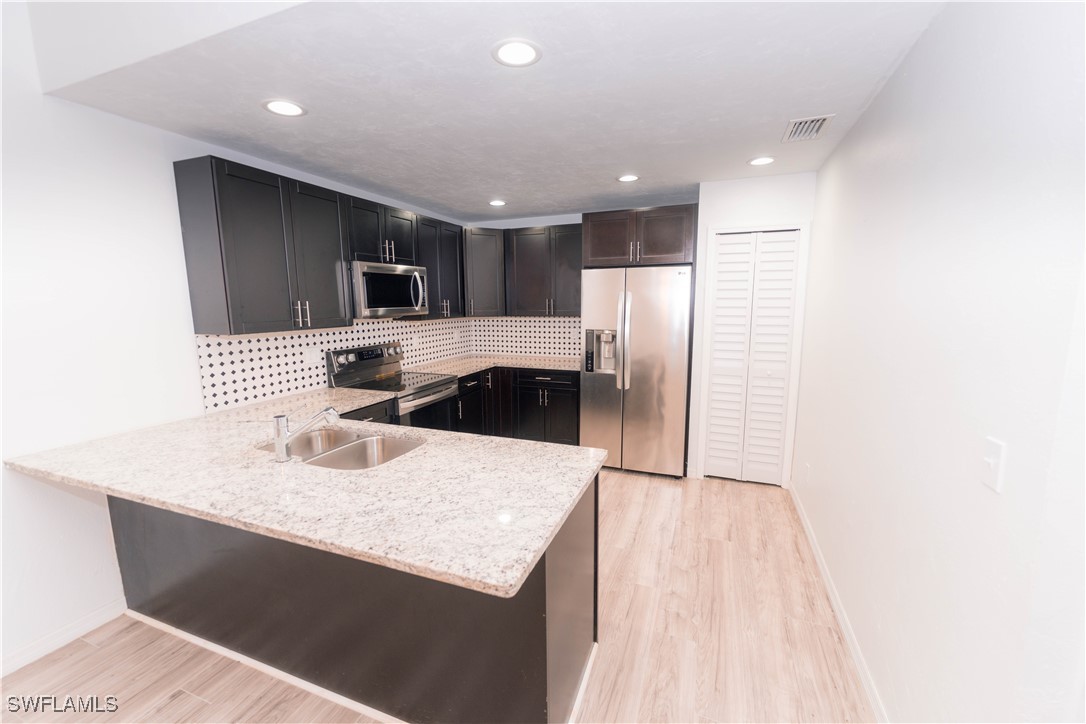 a kitchen with kitchen island a sink stainless steel appliances and cabinets