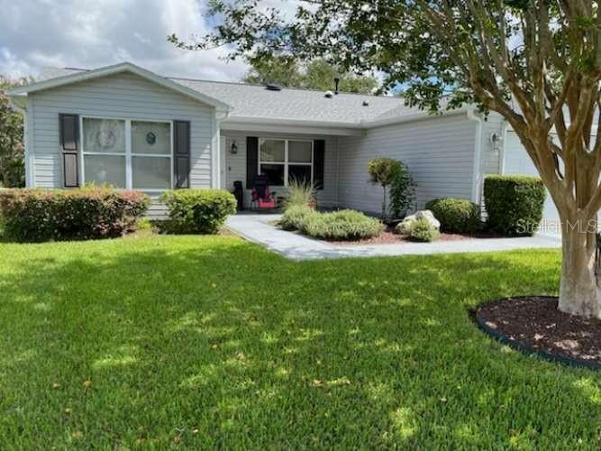 a front view of a house with a yard and green space