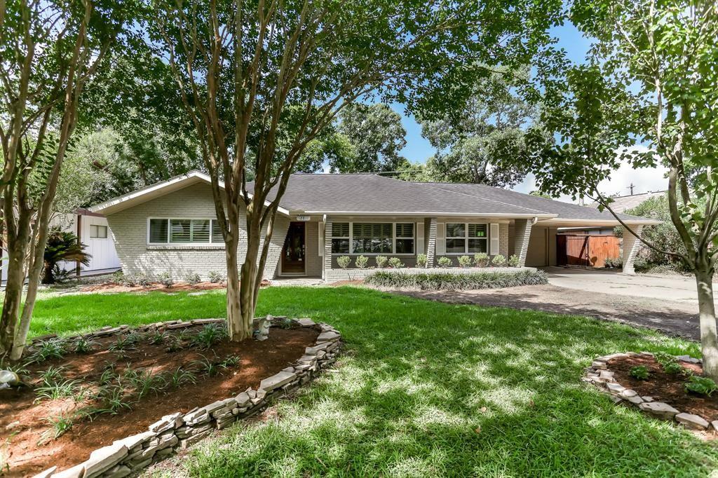 a front view of a house with a yard and trees