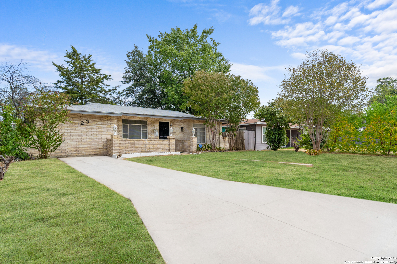 a front view of a house with a yard and trees