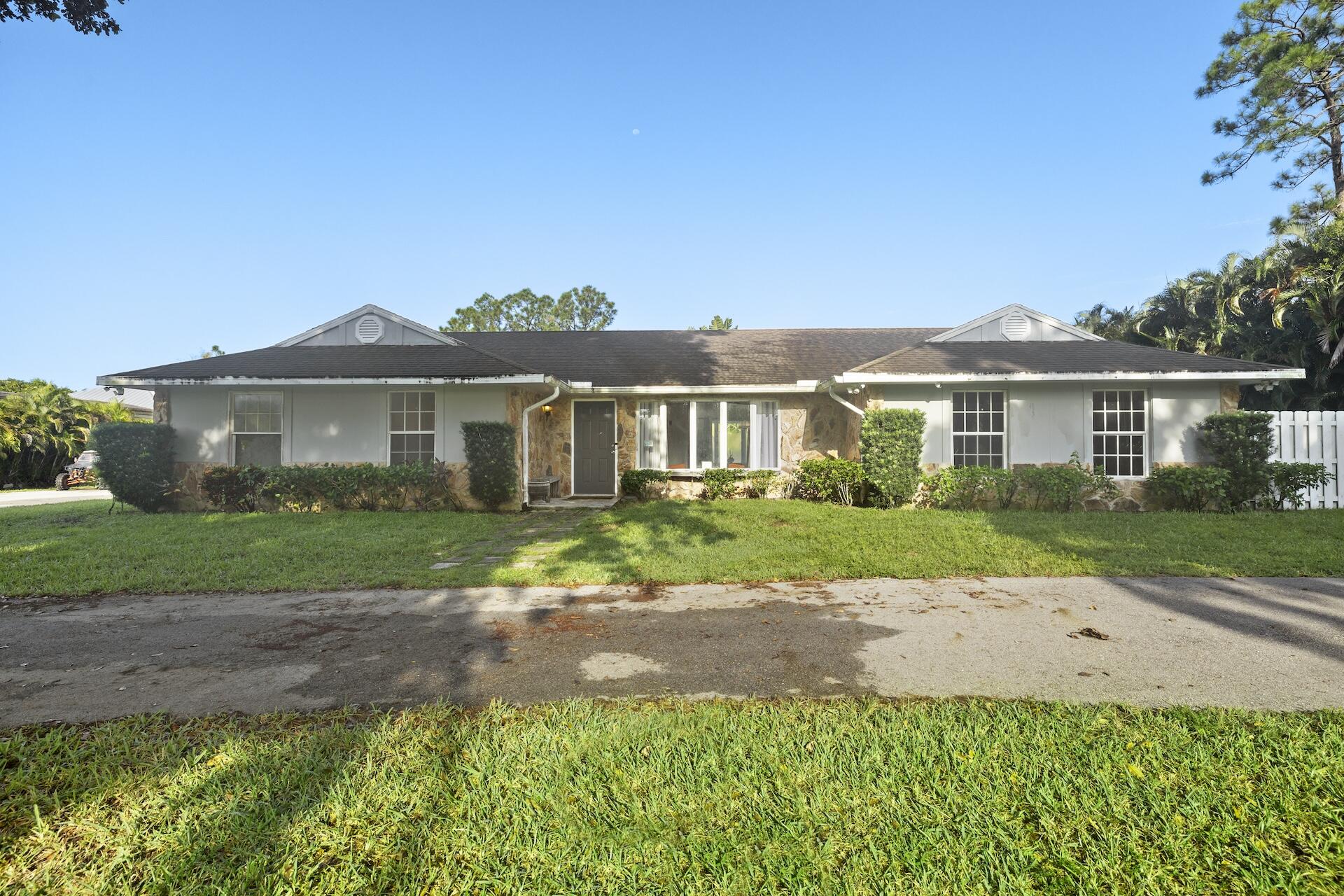 a front view of a house with a garden and yard