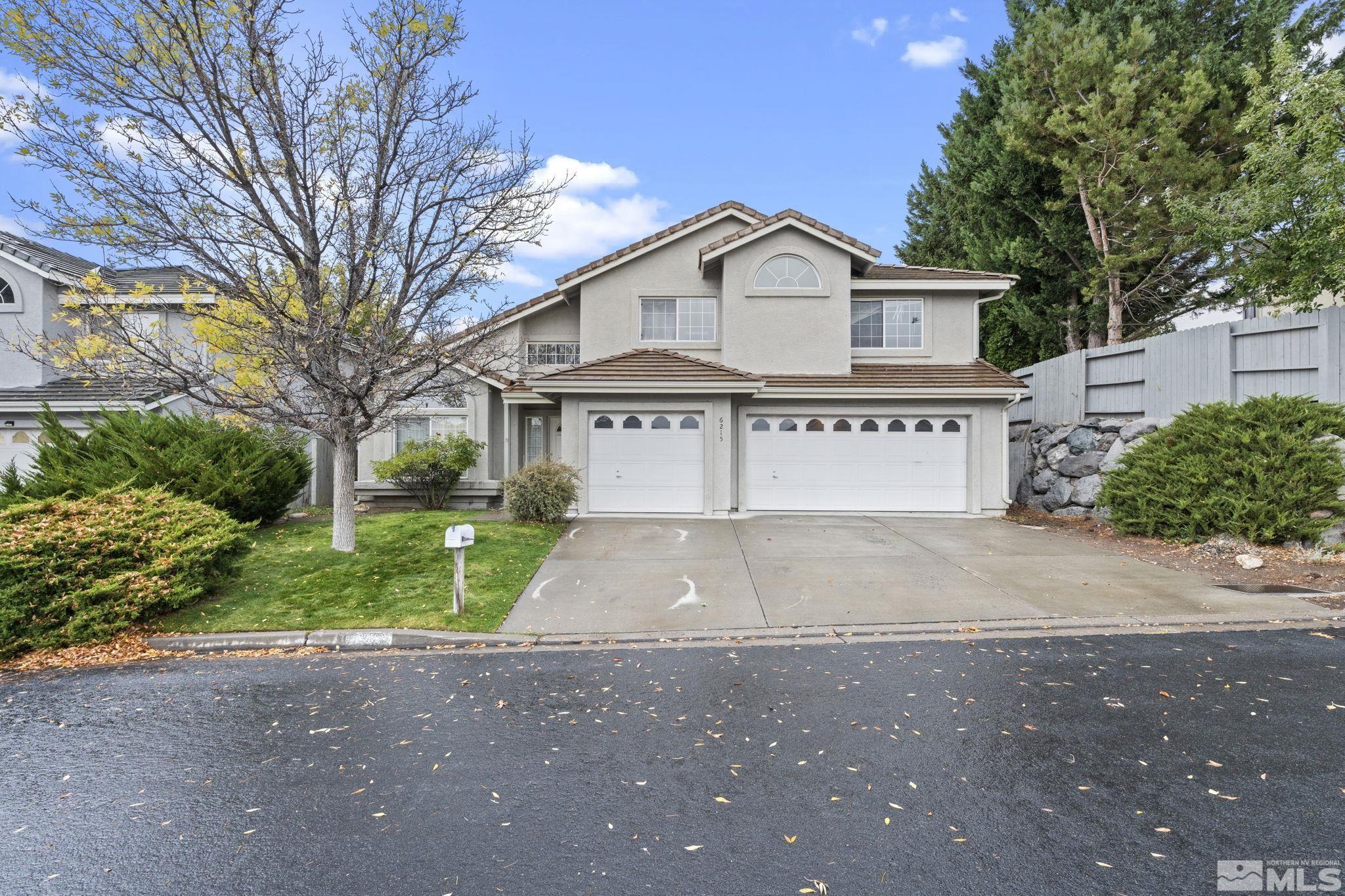 a view of front of house with a yard and garage