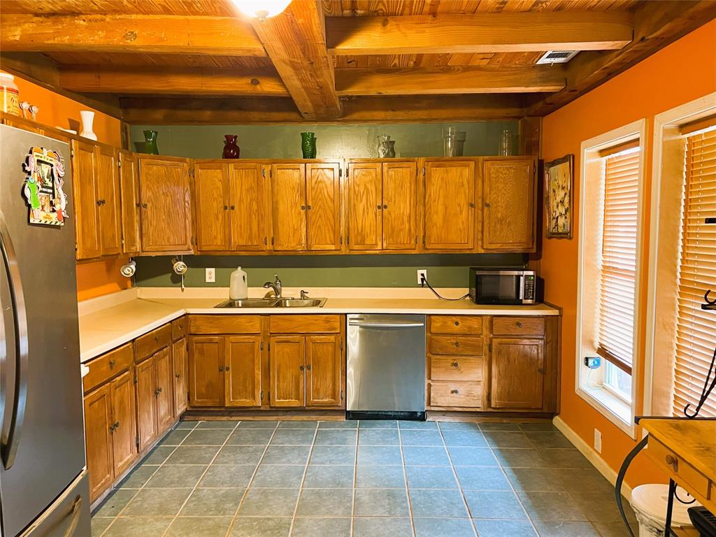 a large kitchen with stainless steel appliances a stove a sink and a refrigerator