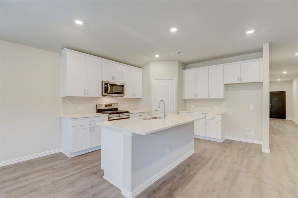 a kitchen with stainless steel appliances a sink stove and refrigerator