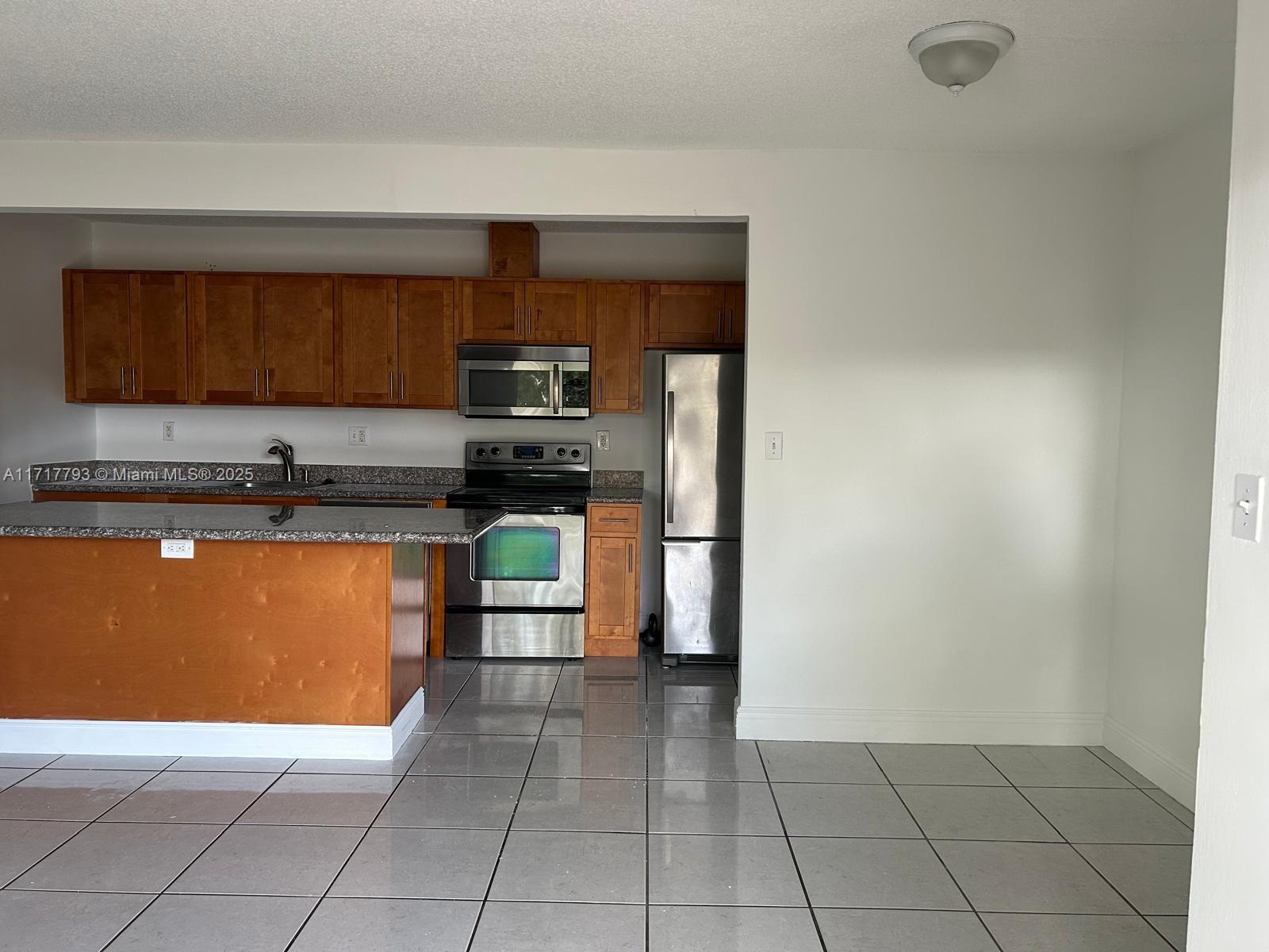 a kitchen with stainless steel appliances a refrigerator and a stove top oven