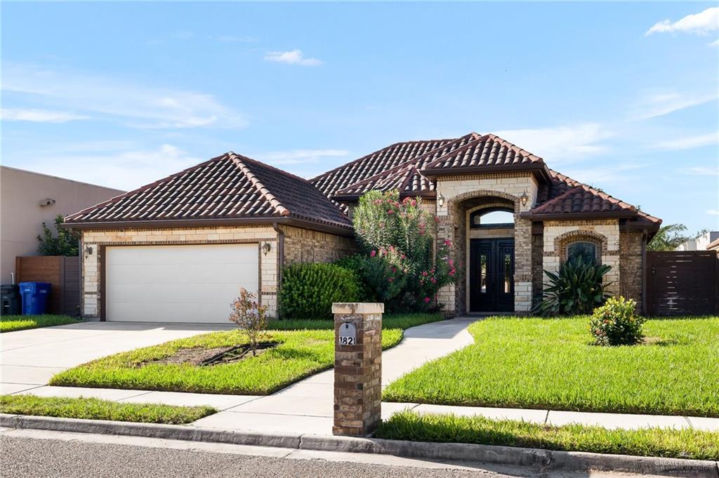 a front view of a house with a yard and garage