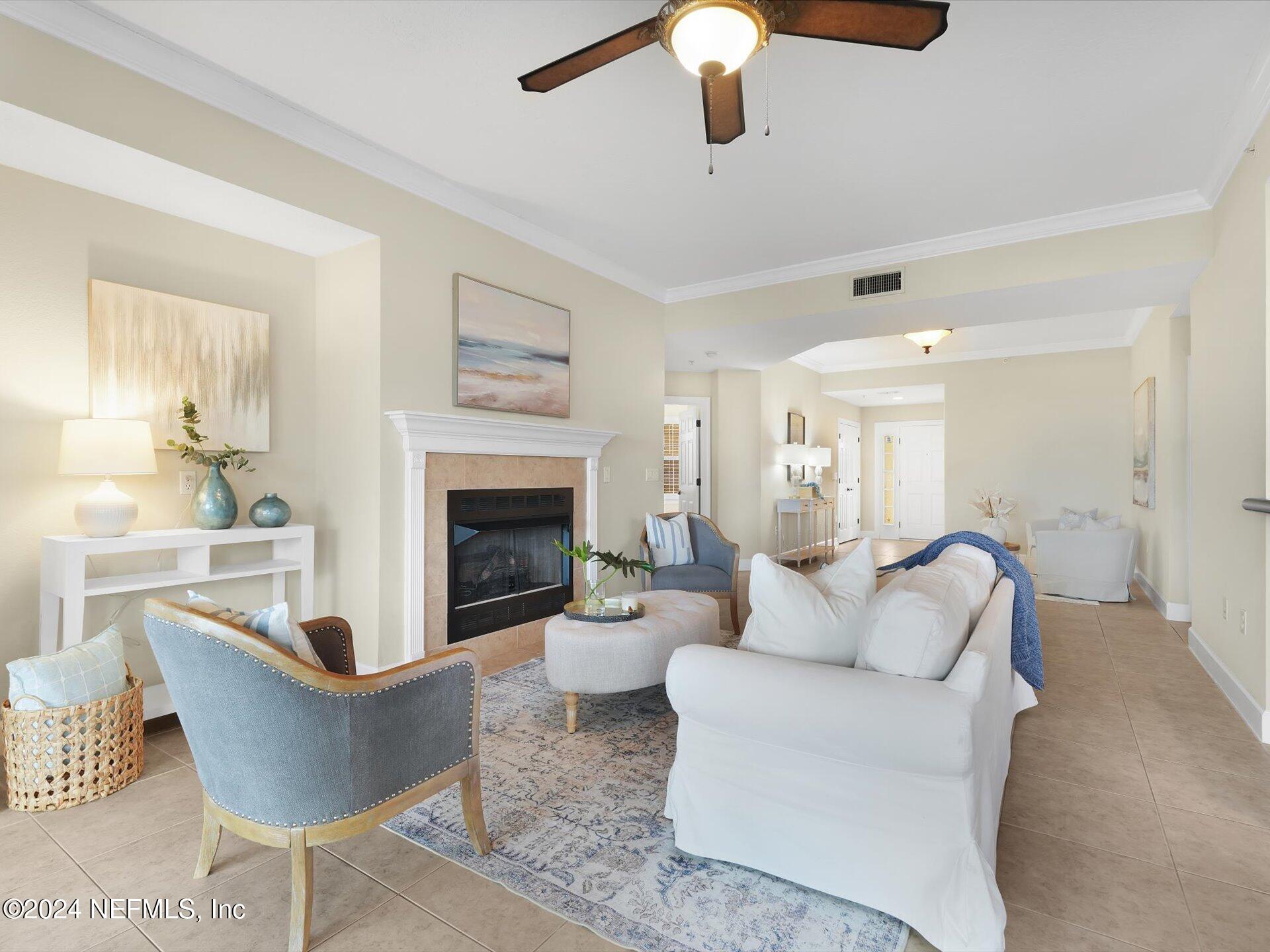 a living room with furniture a fireplace and a chandelier