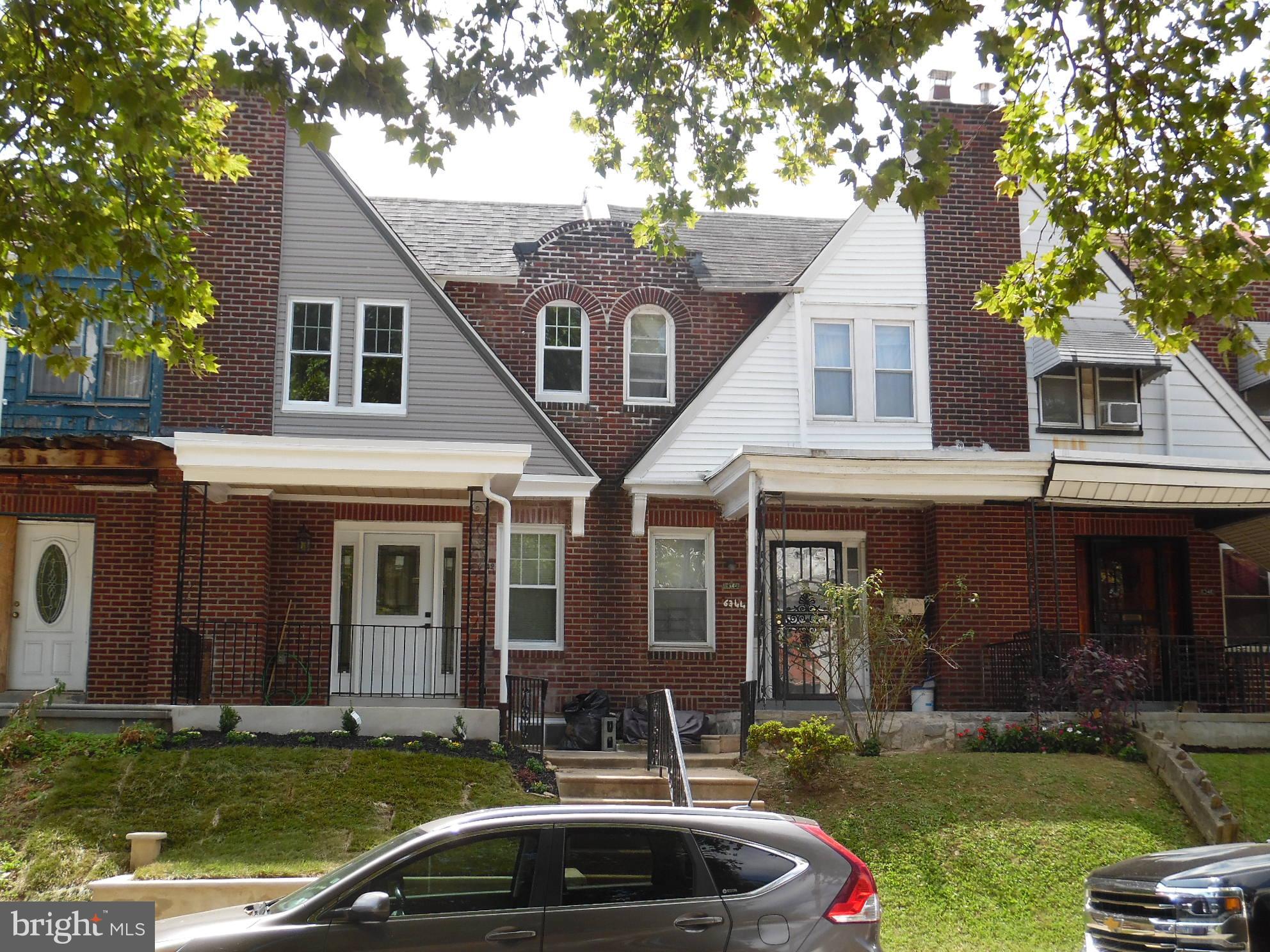 a front view of a house with a garden and yard