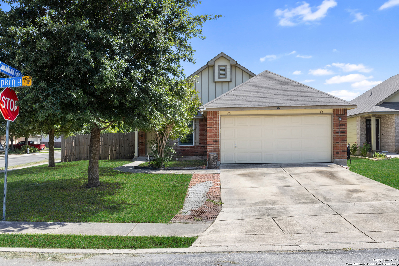 a front view of a house with a yard and trees