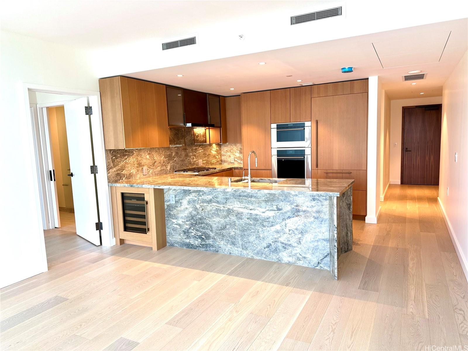 a view of a kitchen with kitchen island granite countertop a refrigerator and a sink