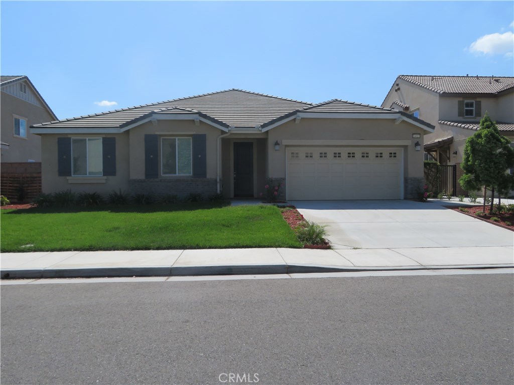 a front view of a house with a garden and yard