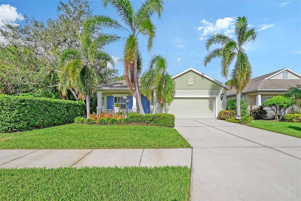 a front view of a house with a garden and trees