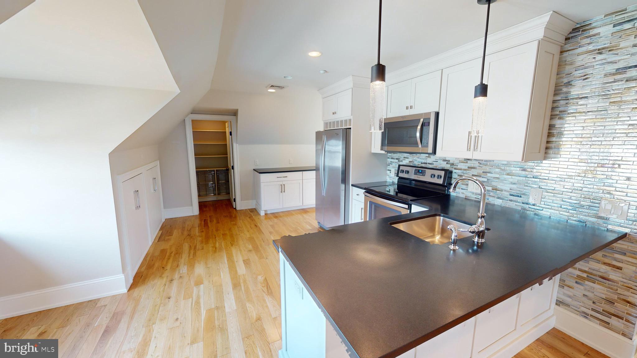 a kitchen with a sink appliances and cabinets