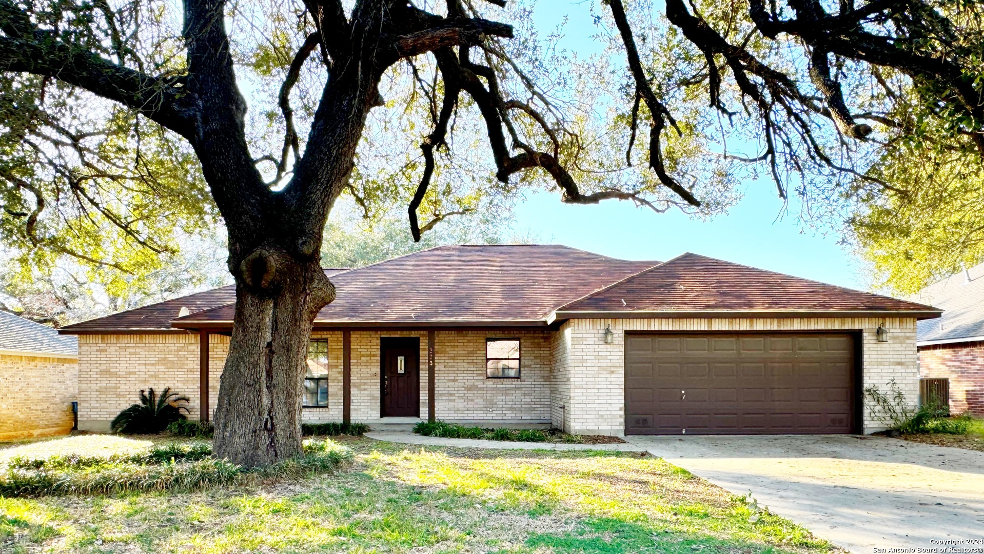 a front view of a house with yard and trees