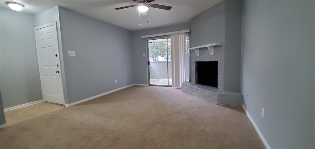 a view of an empty room with chandelier fan