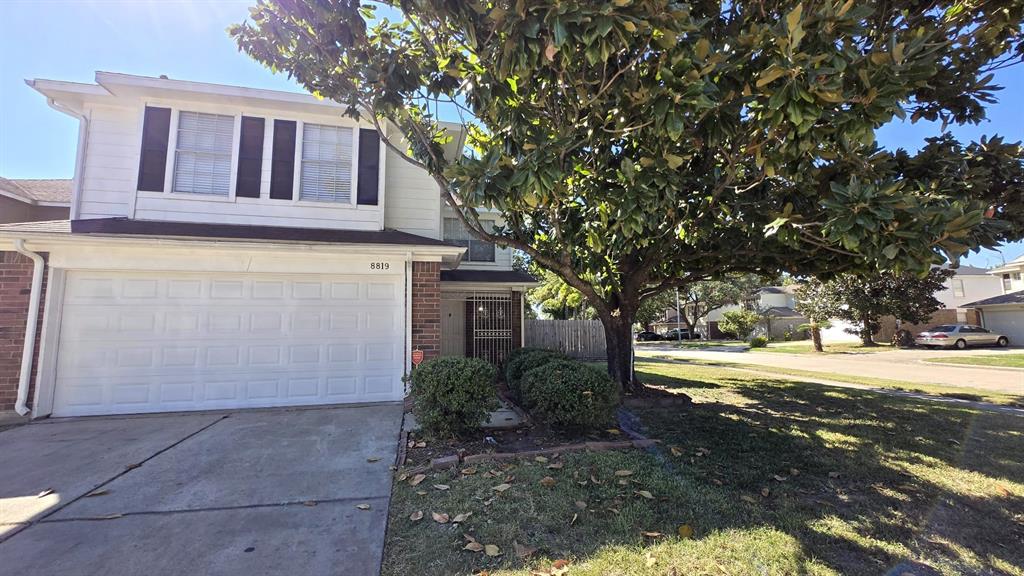 Front of home with mature tree.