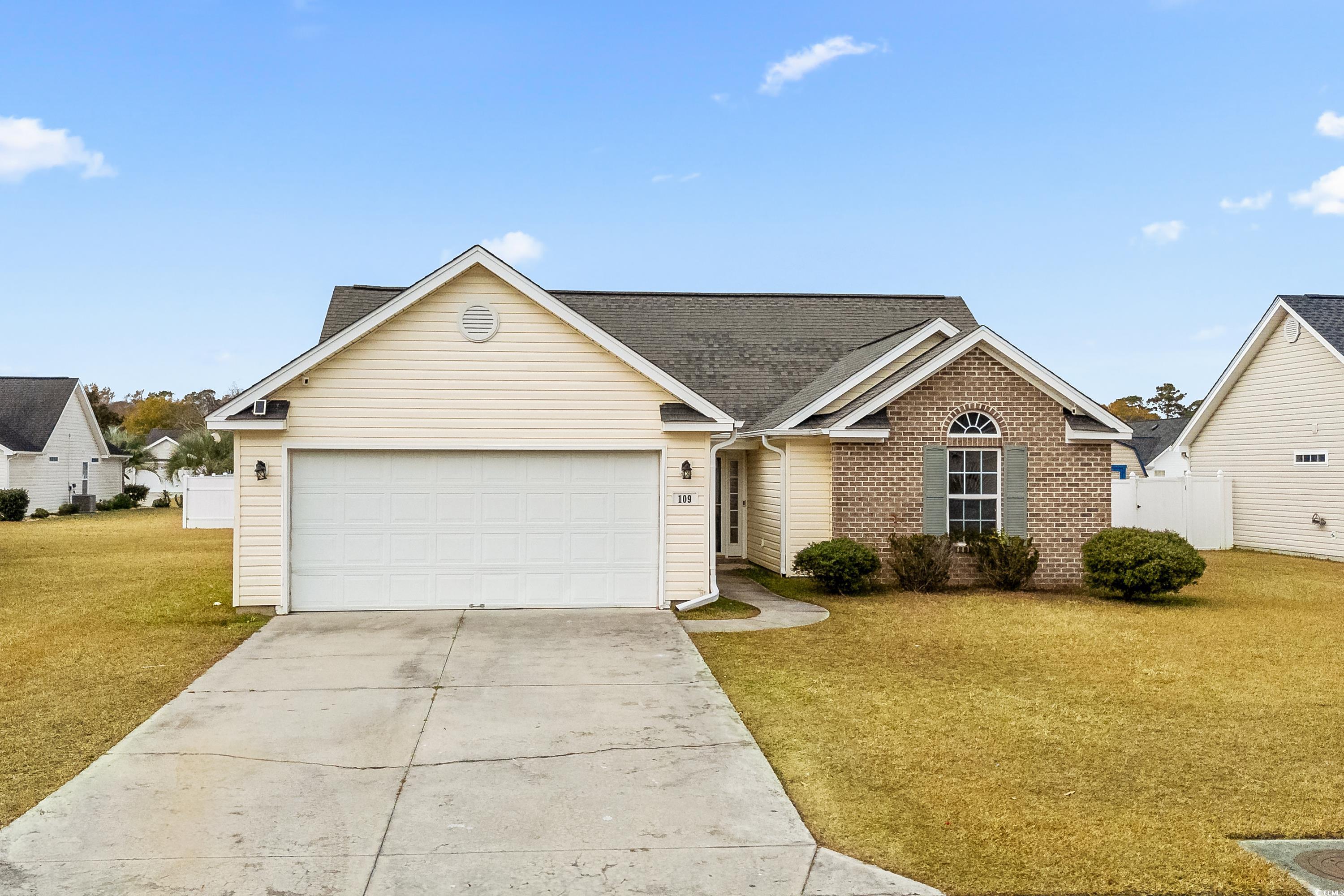 Ranch-style house with a garage and a front lawn