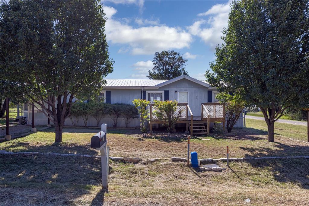 a view of a house with backyard and tree