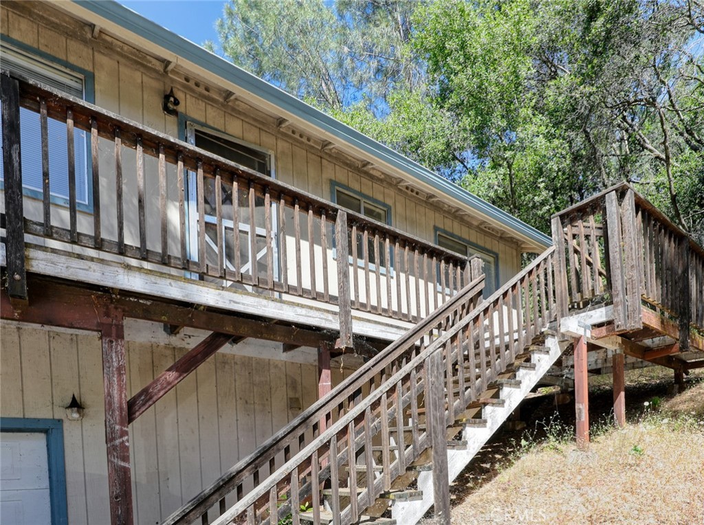 a view of balcony with wooden stairs and deck