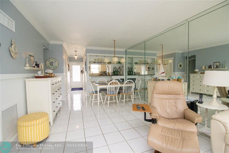 a living room with furniture a table and kitchen view