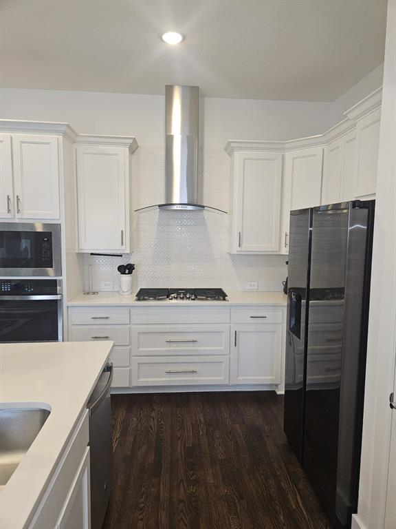 a kitchen with a refrigerator stove and white cabinets