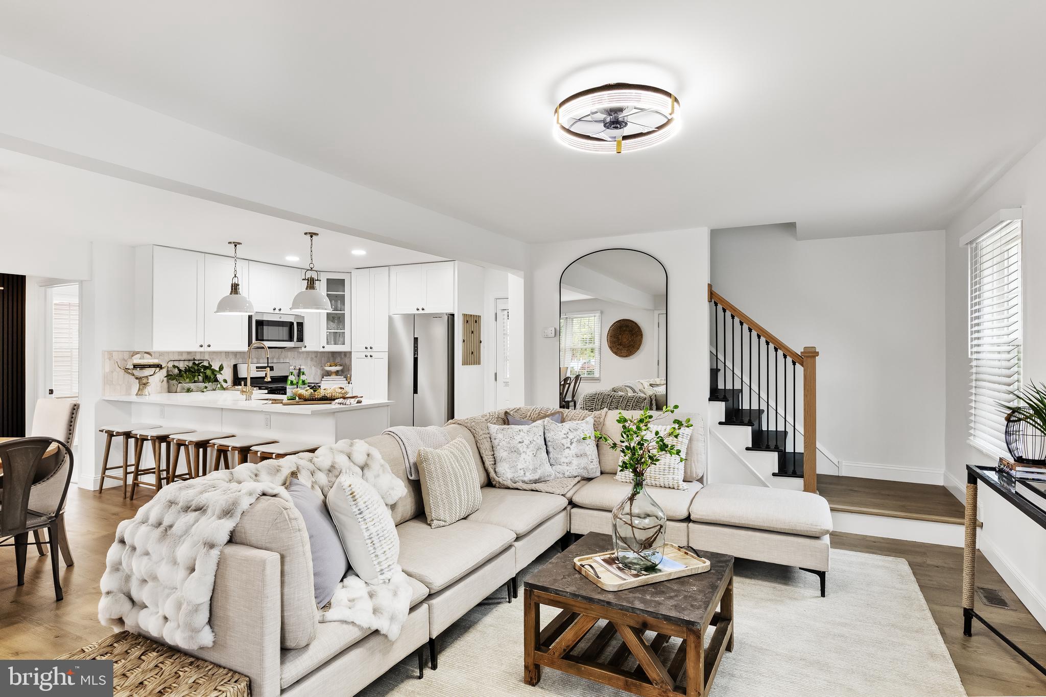 a living room with furniture white walls and a dining table