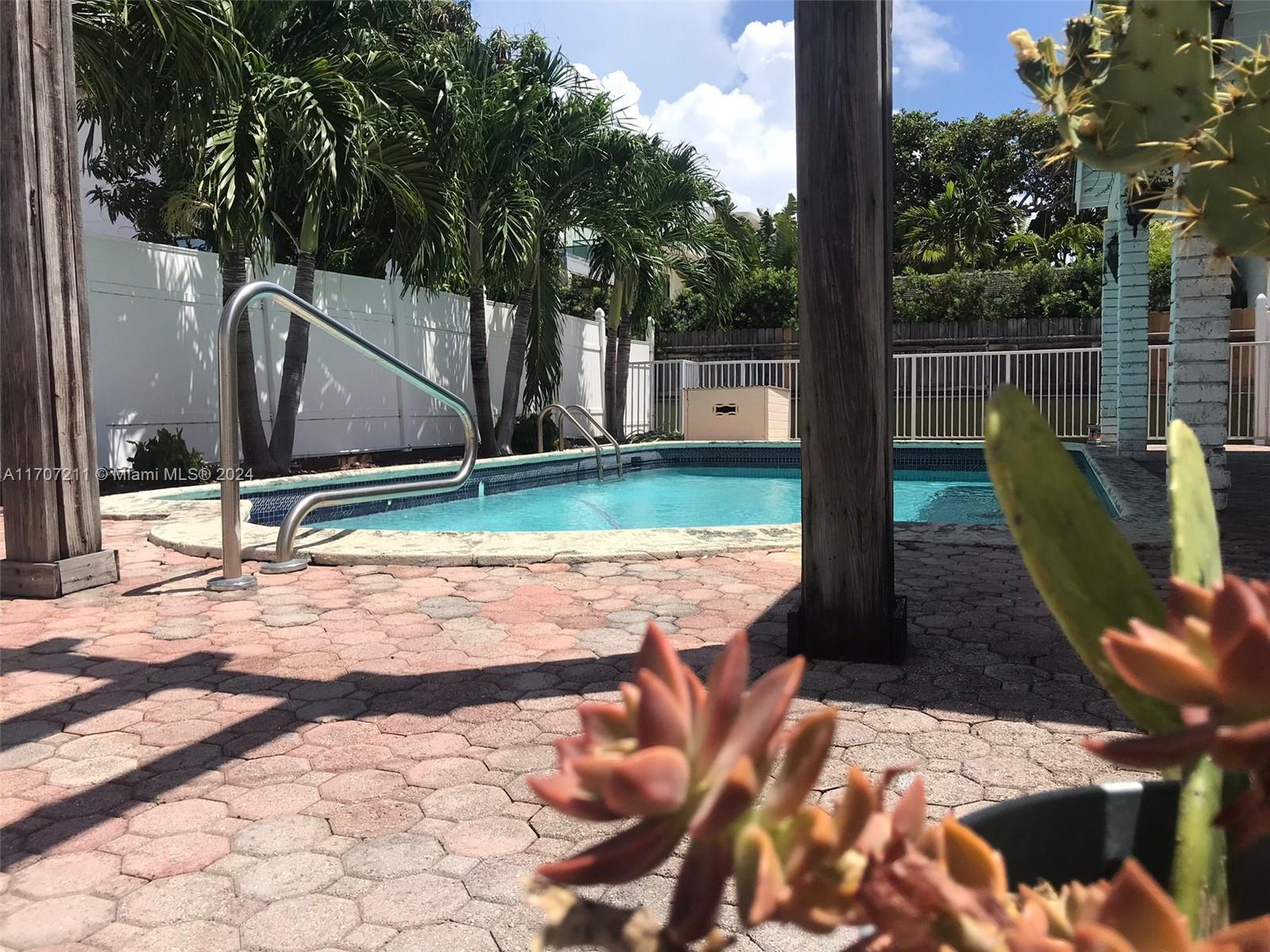 a view of a backyard with couches chair and floor to ceiling window