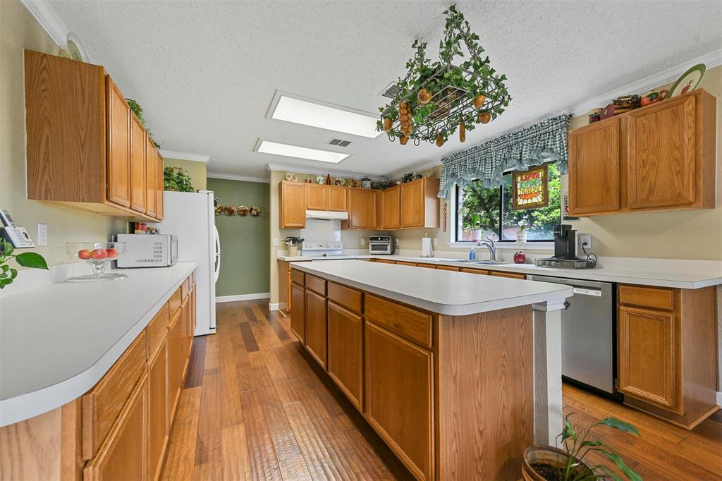 a kitchen with kitchen island granite countertop a sink stove and cabinets