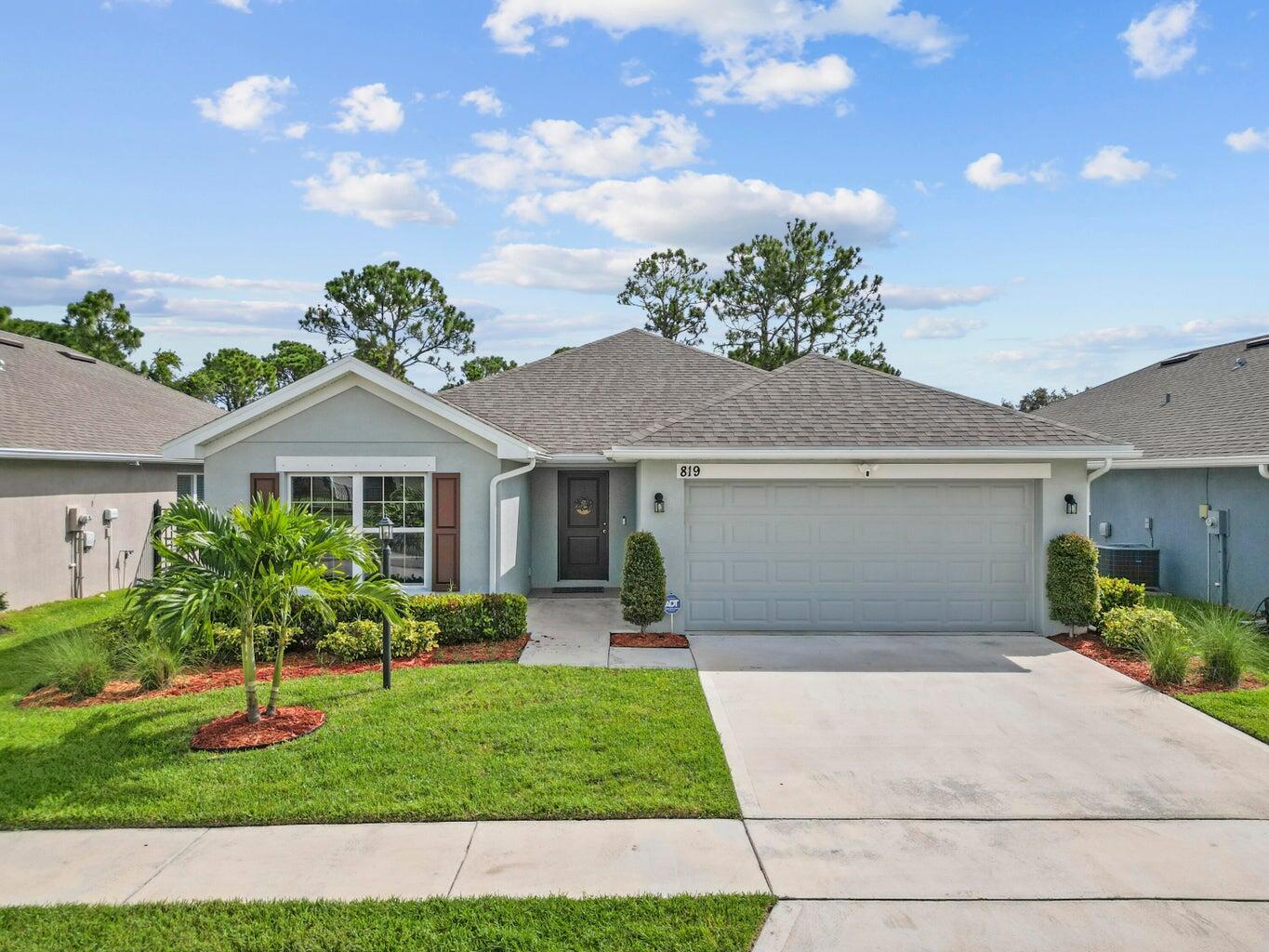 a front view of a house with a yard and garage