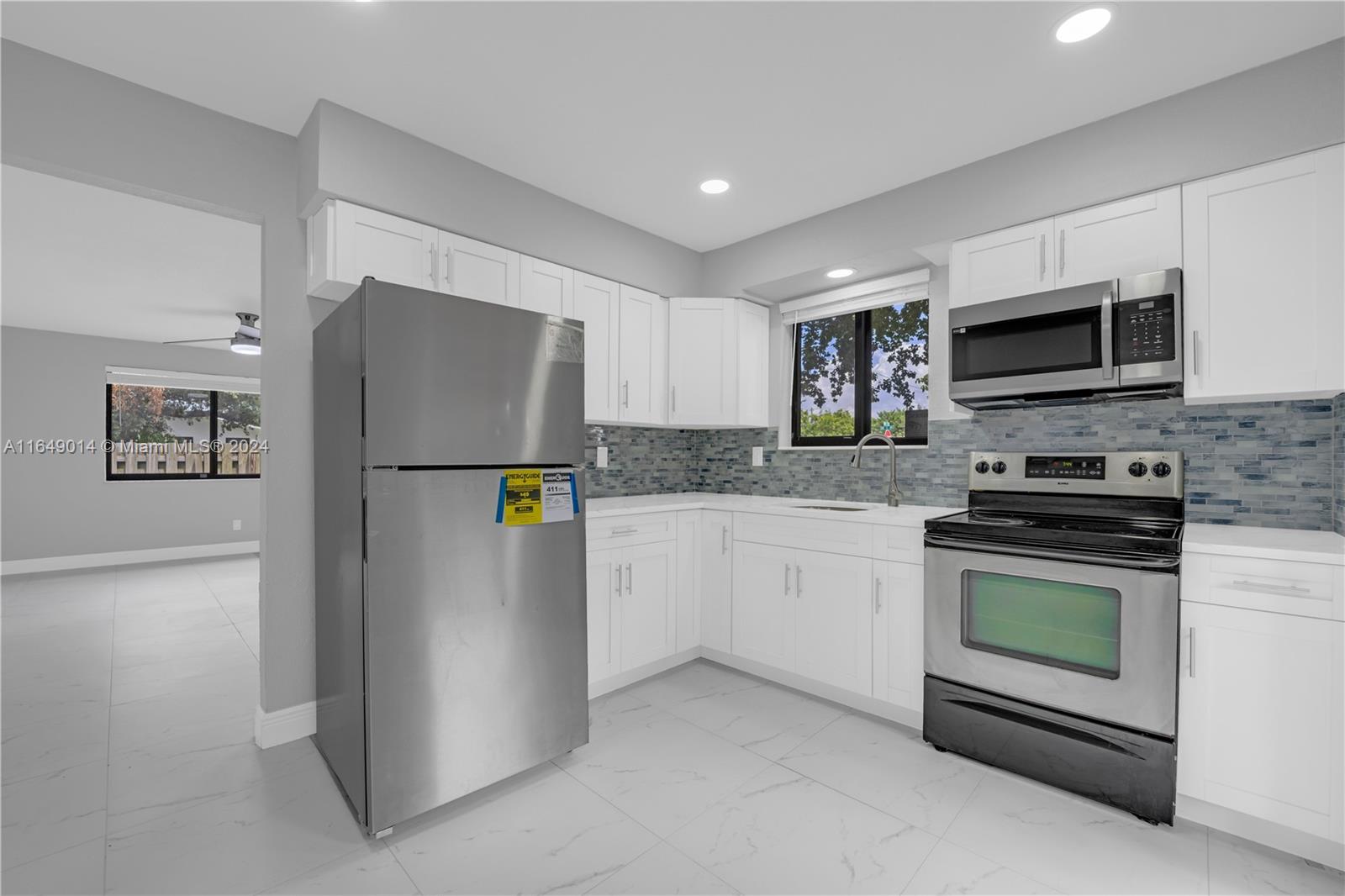 a kitchen with stainless steel appliances white cabinets and a refrigerator