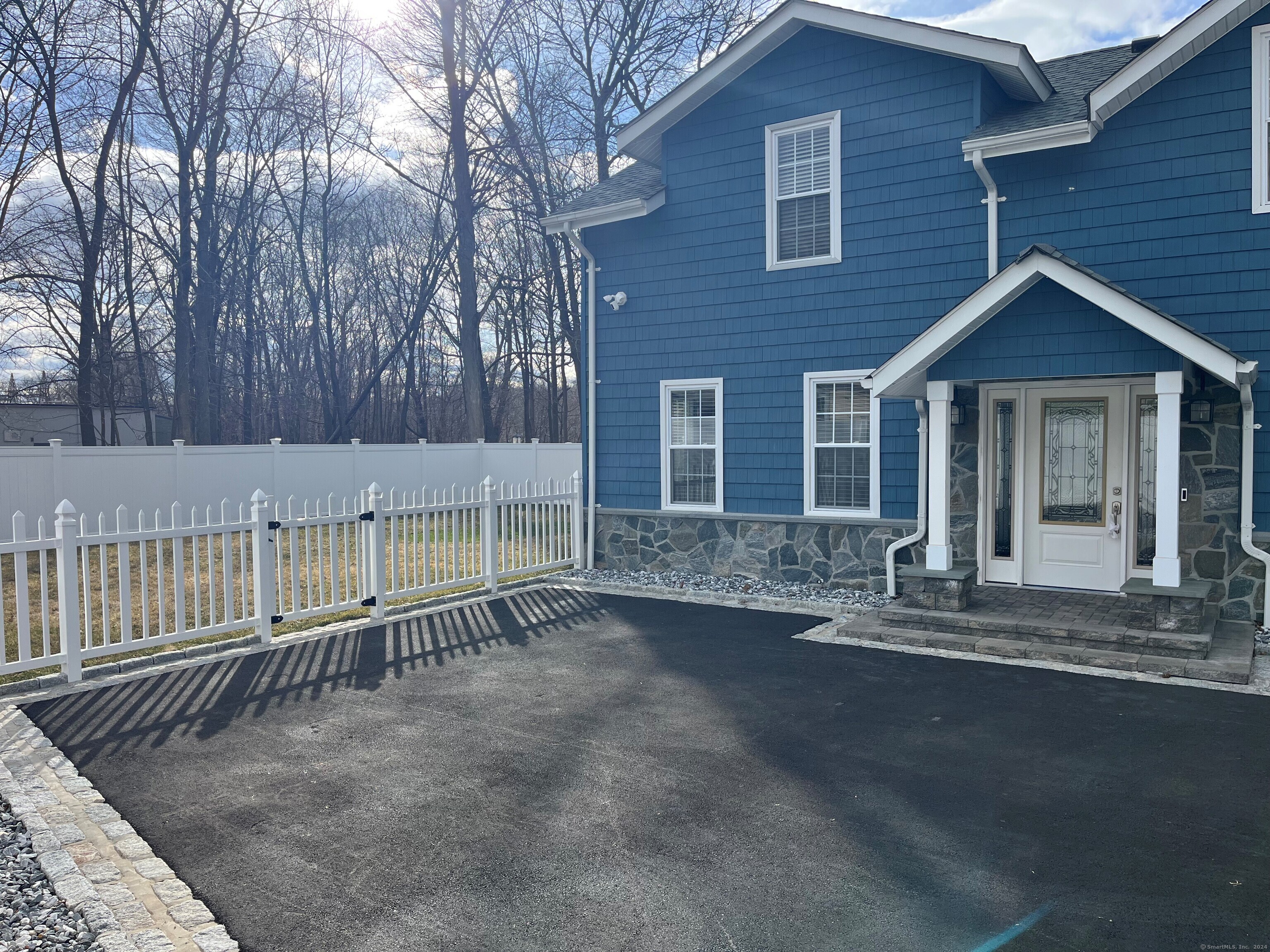 a view of a house with a small yard and wooden fence