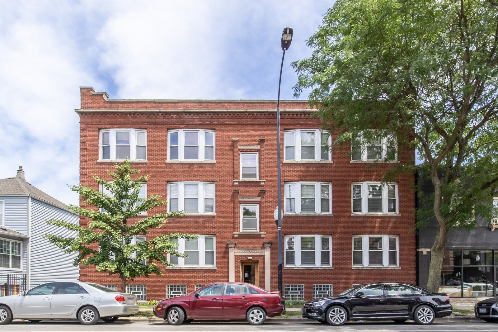 a front view of a residential apartment building with a yard