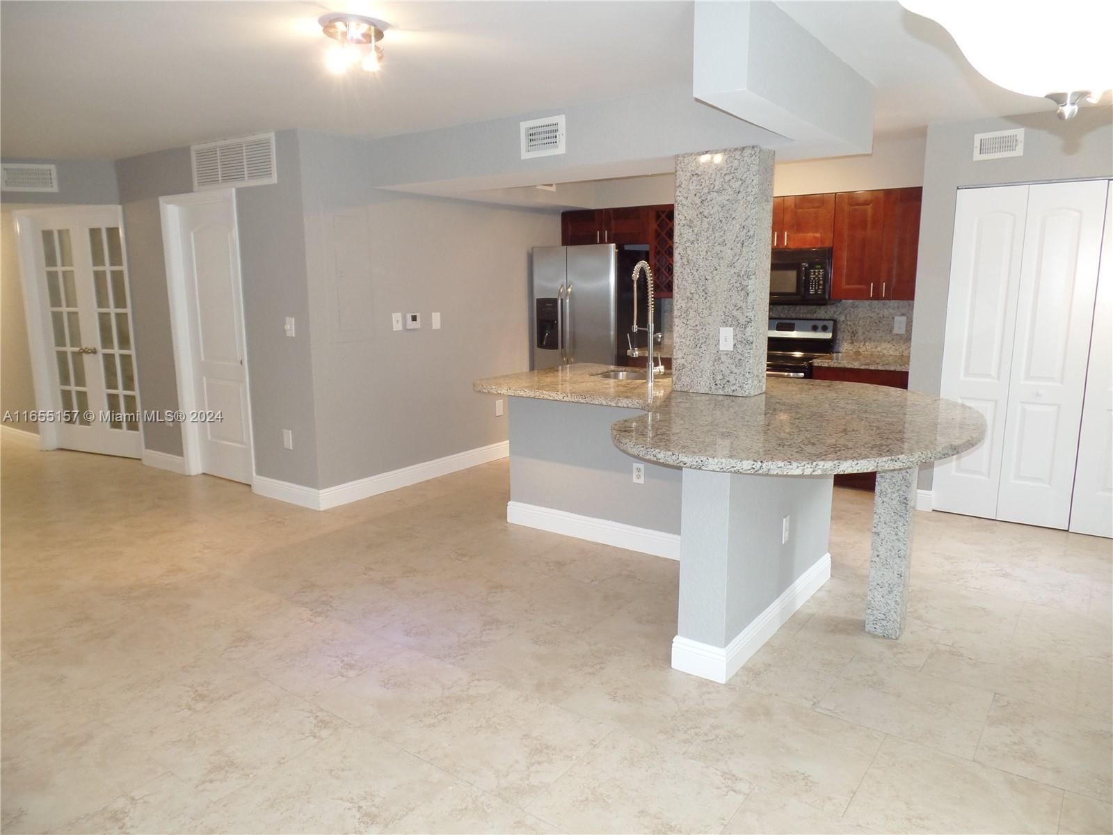 a kitchen with stainless steel appliances granite countertop a sink and a refrigerator