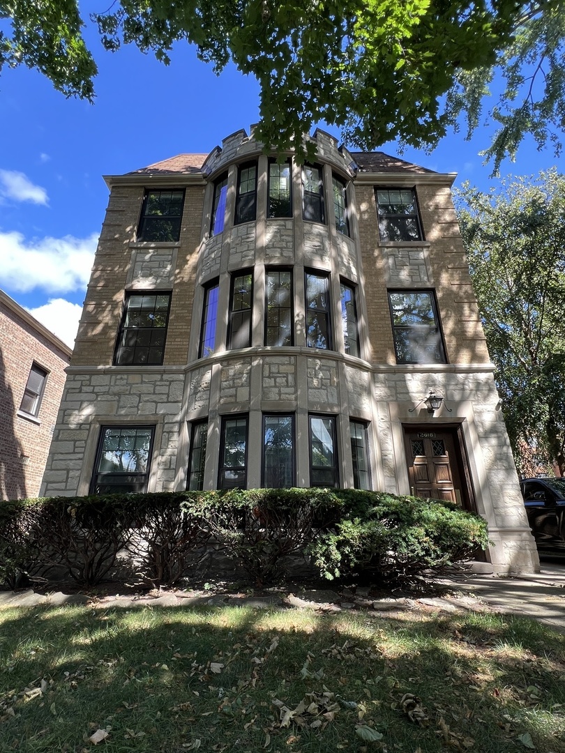 a front view of a residential apartment building with a yard