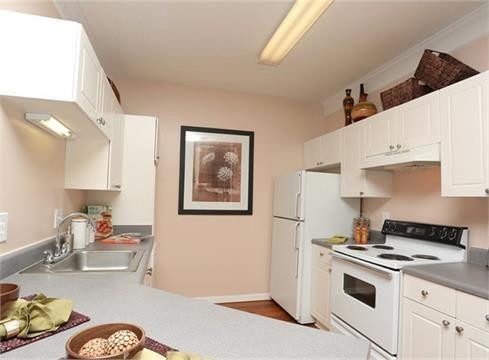 a kitchen with a white stove top oven and cabinets