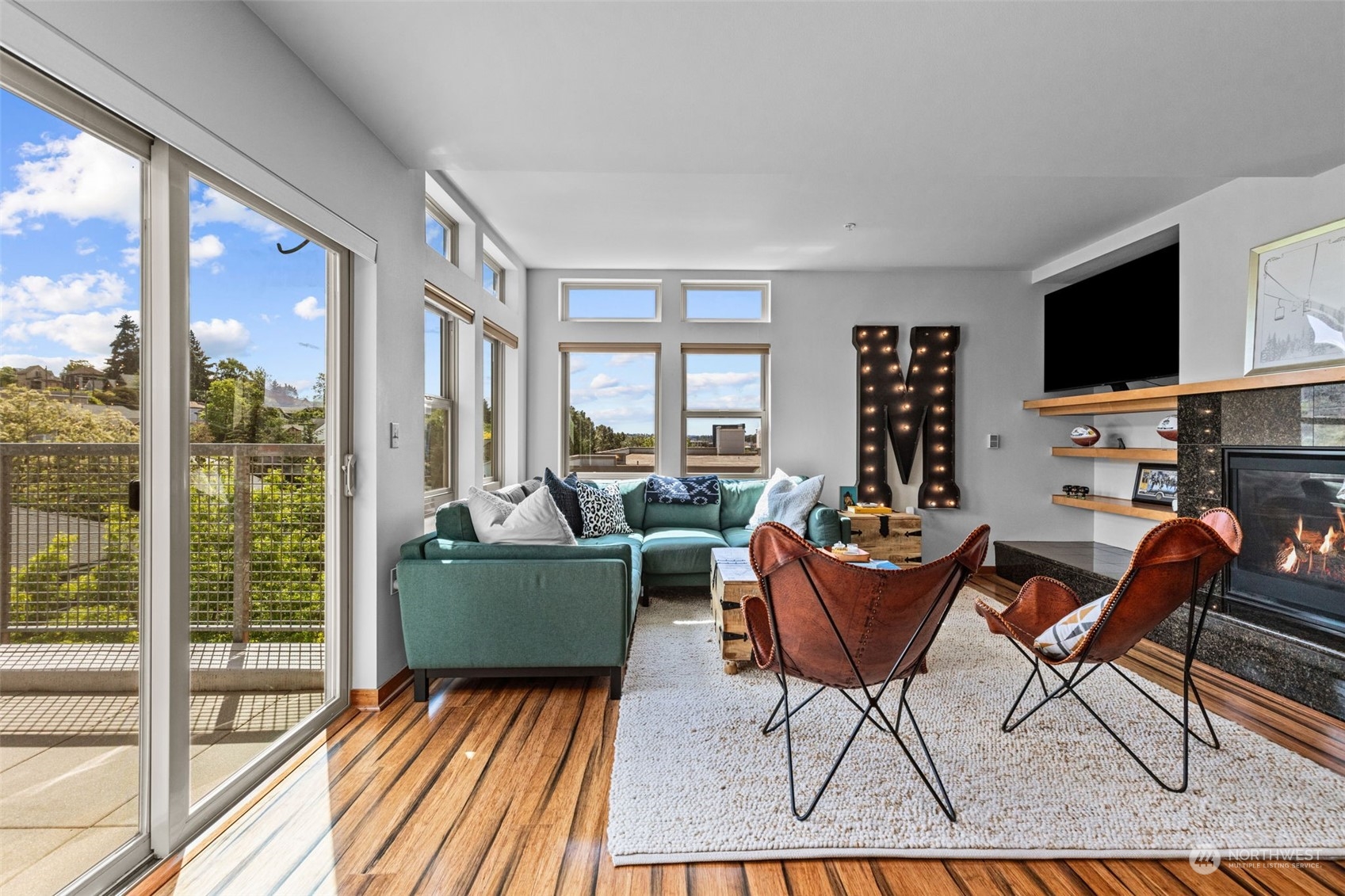 a living room with furniture a flat screen tv and a large window